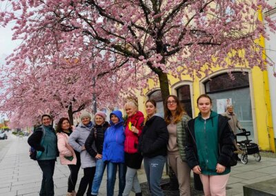 Pracownice CIT Barlinek z uczestniczkami rajdu NW z Barlinka i Mostkowa na tle kwitnących wiśni podczas zwiedzania miasta Prenzlau
