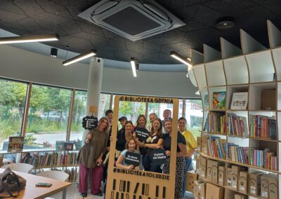 na zdjęciu widać grupę 11 osób pozujących do zdjęcia w bibliotece dziecięcej w Gdyni