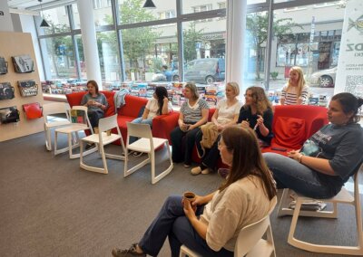 na zdjęciu widać kilka osób siedzących i słuchających prelekcji w bibliotece w Gdyni